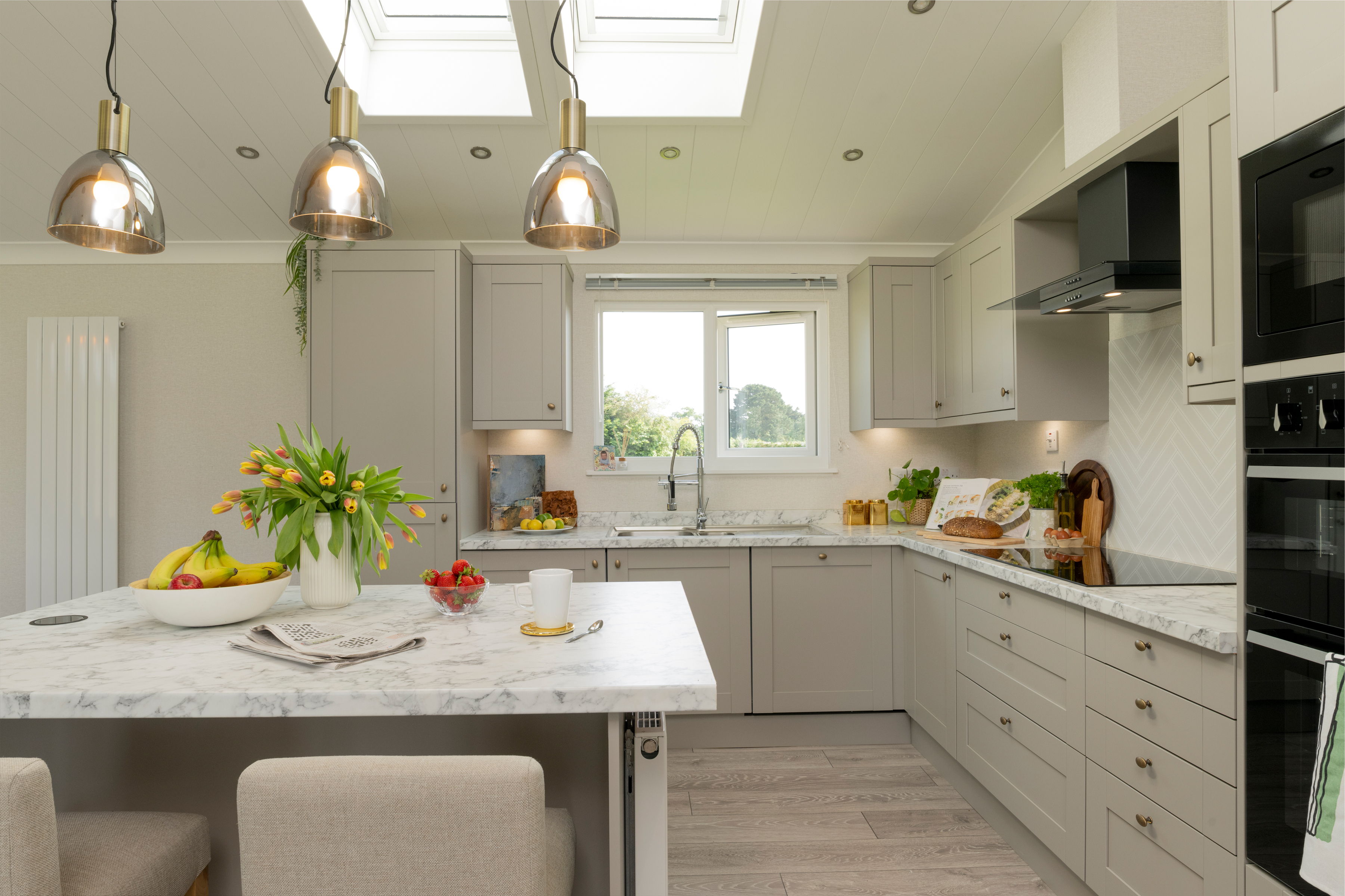 Modern kitchen with island unit, pendant lights and bar stools