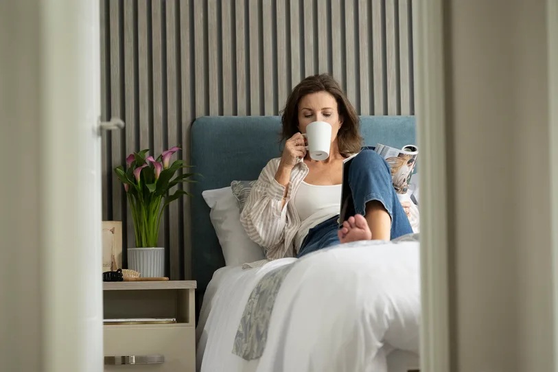 Woman drinking tea in bed