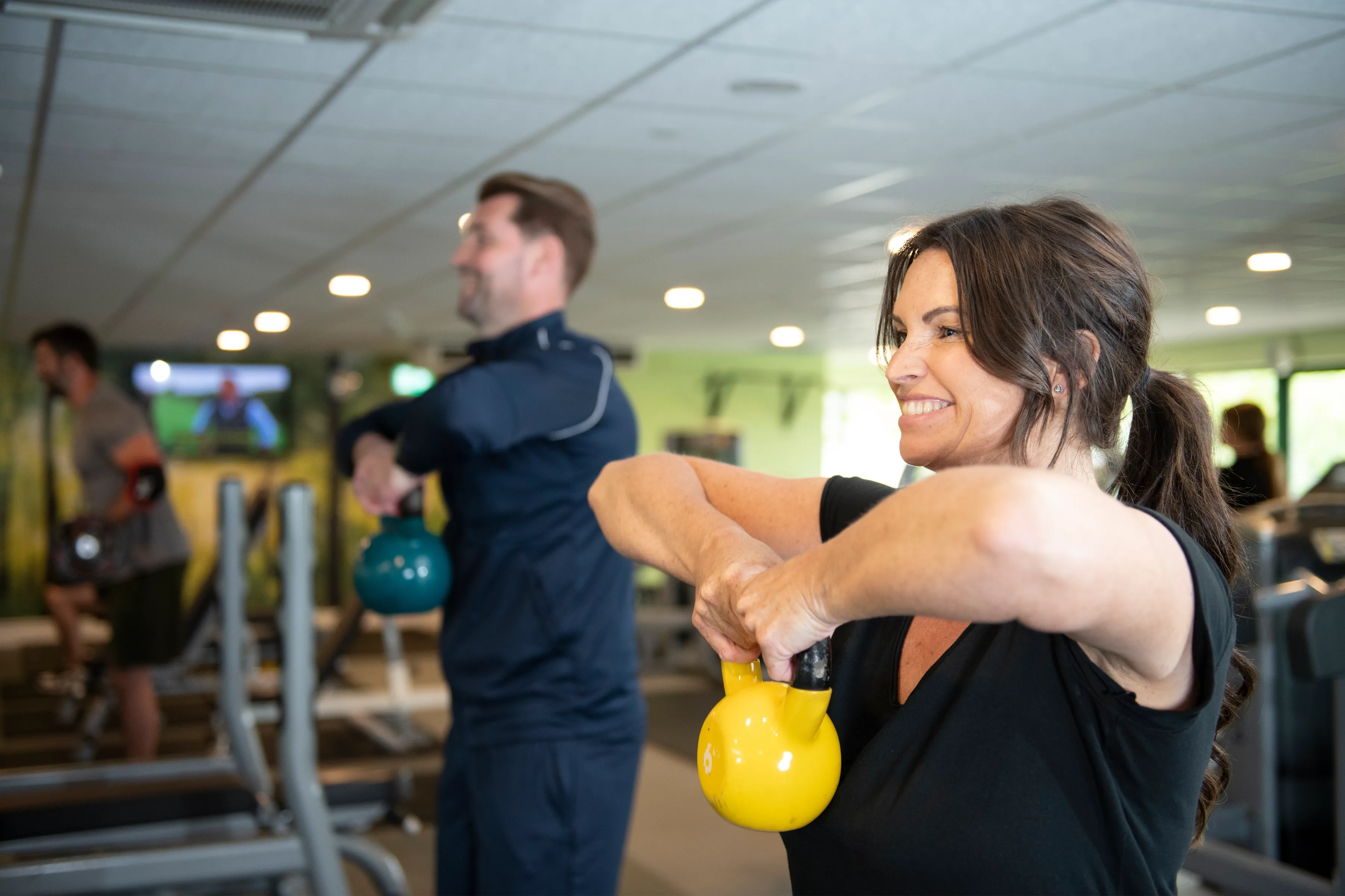 Couple lifting weights in gym