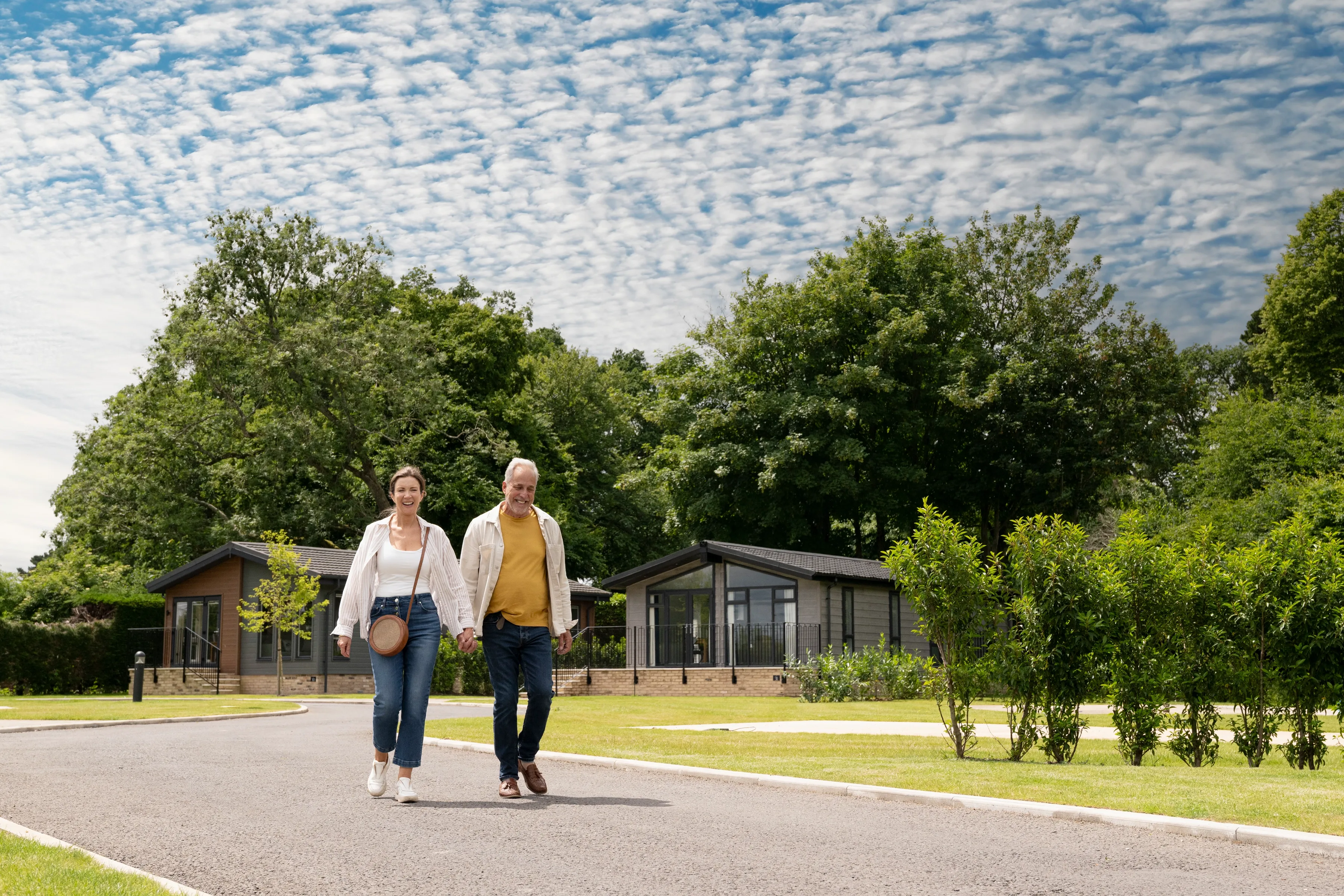 Couple walking through park blue sky
