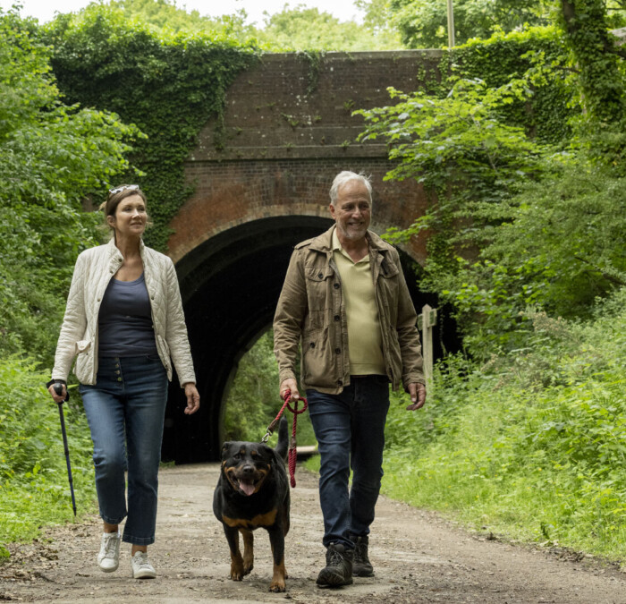 Couple walking dog in forest Square